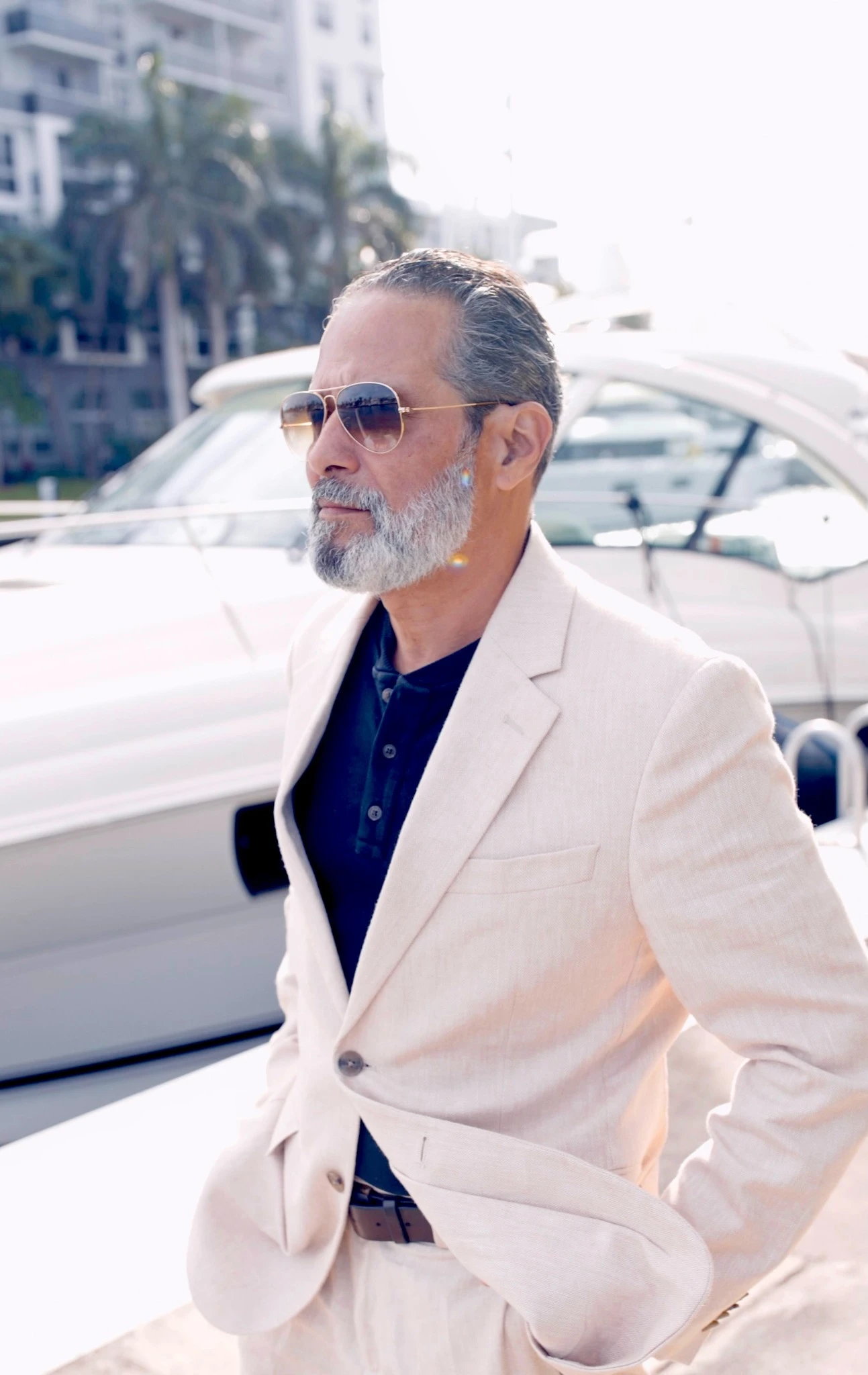 Anthony in a cream suit standing beside a boat