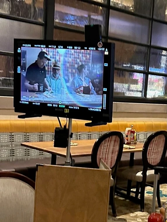 Production monitor showing Anthony performing in a restaurant scene during the Hard Rock Tampa shoot